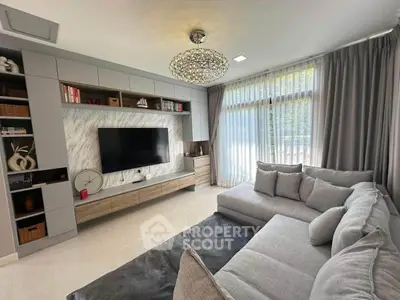 Modern living room with stylish decor, large TV, and cozy sectional sofa in a bright, airy space.