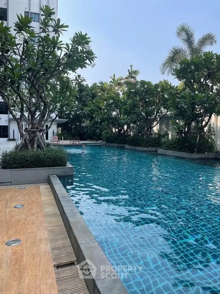 Luxurious residential pool surrounded by lush greenery and modern architecture, perfect for relaxation and leisure.