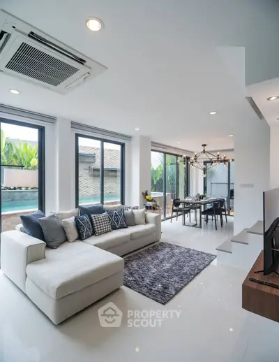 Modern living room with large windows and stylish decor in a luxury home.