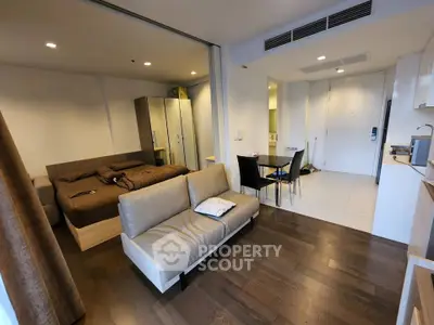 Modern studio apartment with open layout, featuring cozy living area and stylish bedroom.