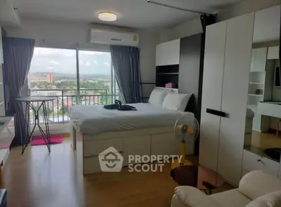 Modern bedroom with large window offering stunning city view and ample storage space.