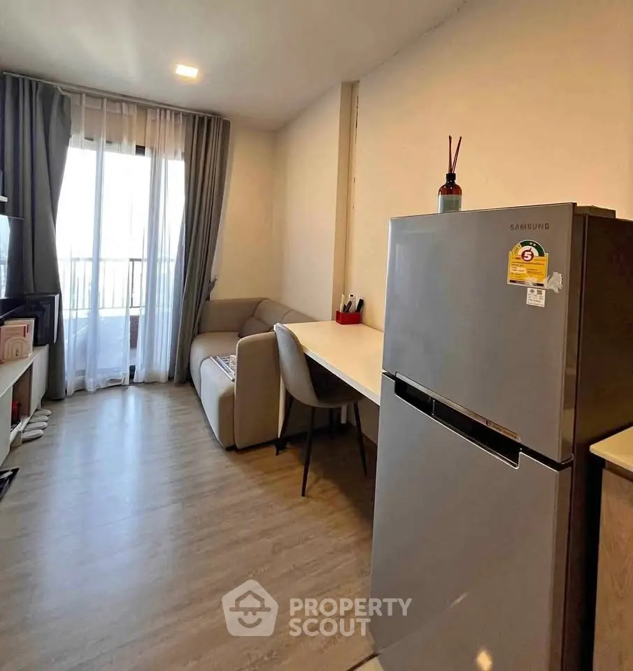 Modern living room with cozy seating and sleek refrigerator, perfect for urban living.