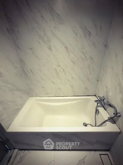 Luxurious marble bathroom with elegant bathtub in modern real estate property.
