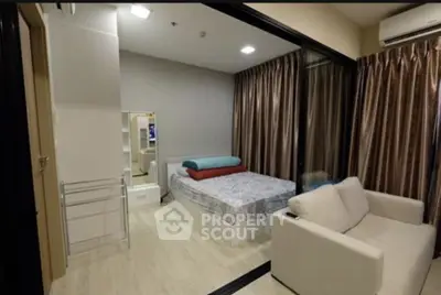 Cozy bedroom with modern decor and comfortable seating area in a stylish apartment.