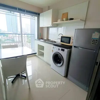 Modern kitchen with washing machine and balcony view in high-rise apartment