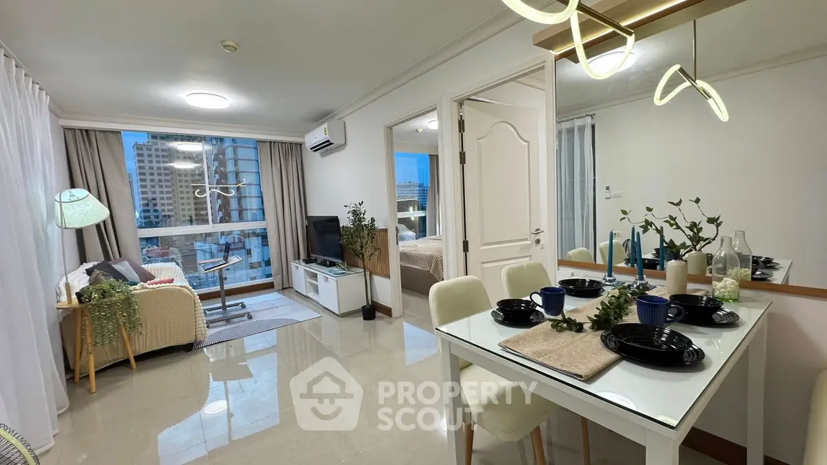 Modern open-plan living room with dining area and city view, stylish decor and ample natural light.