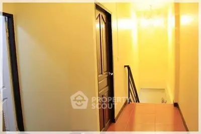 Bright hallway with wooden door and staircase leading down