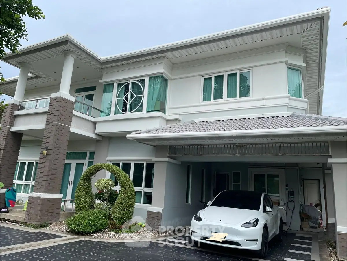 Stunning modern two-story house with sleek design and electric car in driveway.