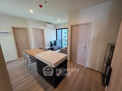 Modern apartment interior with open layout, featuring dining area and living space.