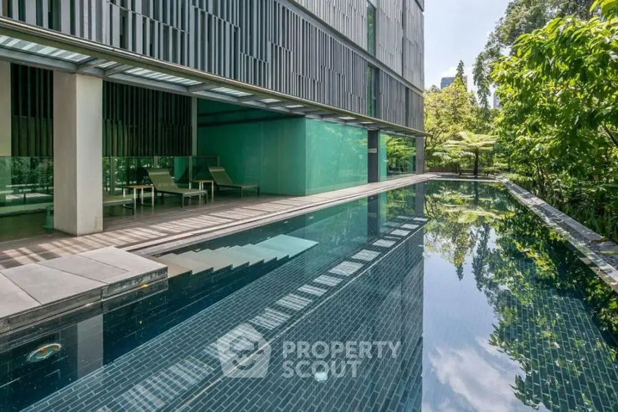 Luxurious modern apartment with serene pool and lush greenery