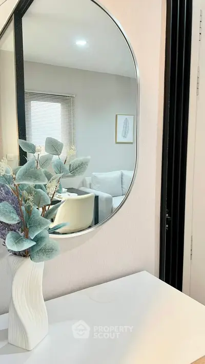 Stylish modern interior with elegant mirror and decorative vase in a cozy living space.