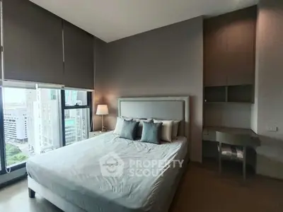 Modern bedroom with city view, featuring a stylish bed and sleek furniture, perfect for urban living.