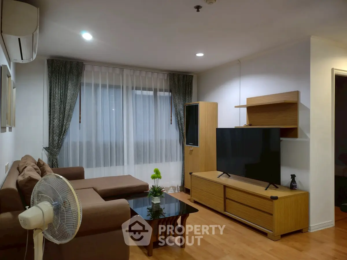 Spacious living room with modern furniture and large TV, perfect for relaxation.