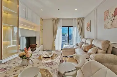 Luxurious living room with plush seating and elegant decor, featuring a large window with city view.