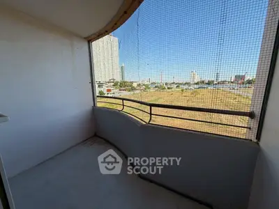 Spacious balcony with panoramic city view in modern high-rise apartment.