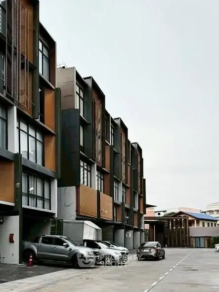 Modern townhouse complex with parking area and contemporary design.