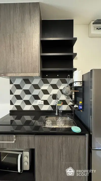 Modern kitchen with sleek cabinets and geometric backsplash design