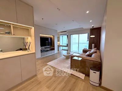 Spacious modern living room with elegant decor and city view, featuring a cozy sofa and stylish lighting.