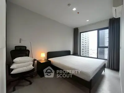 Modern bedroom with city view, featuring sleek furniture and ample natural light.