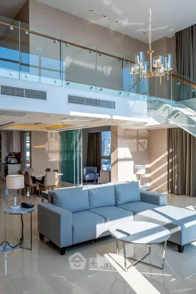 Luxurious modern living room with high ceilings, elegant chandelier, and spacious open layout.