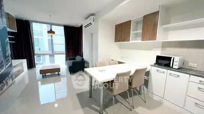 Modern open-plan living room and kitchen with sleek furniture and natural light.