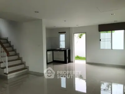 Spacious modern interior with sleek kitchen and staircase, perfect for contemporary living.