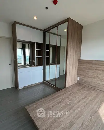 Modern bedroom with built-in wooden wardrobe and sleek flooring