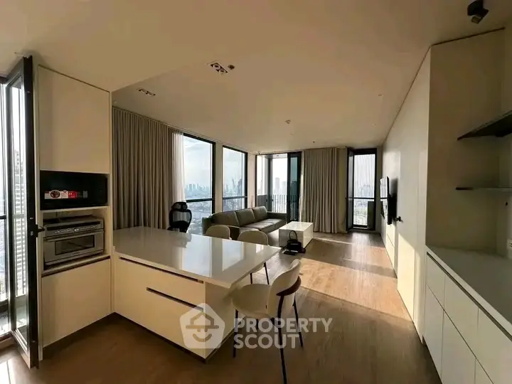 Spacious modern living room with panoramic city views and sleek kitchen design.