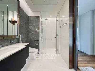 Luxurious modern bathroom with sleek marble finishes and spacious shower area.
