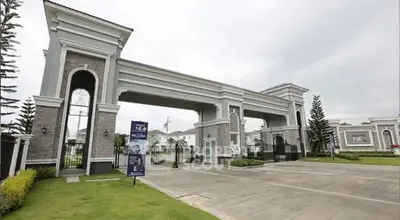 Elegant gated entrance of a luxury residential community with manicured lawns and grand architecture.