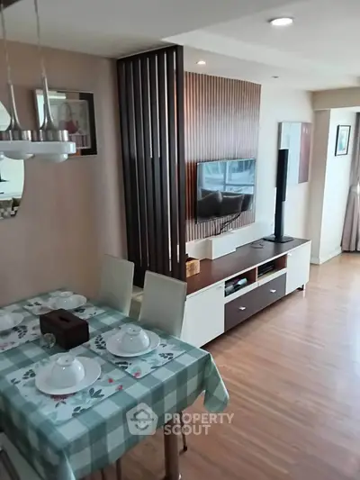 Modern living room with dining area, stylish decor, and wooden flooring in a cozy apartment.