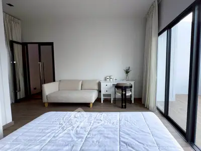 Modern bedroom with elegant decor and large windows offering natural light