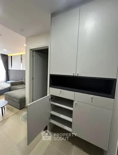 Modern apartment interior with sleek storage cabinets and cozy living area.