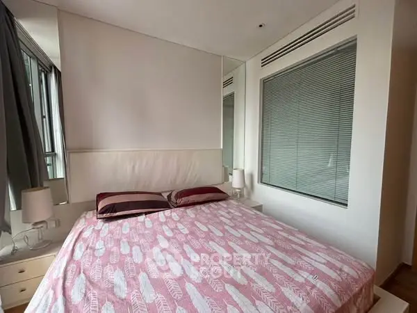 Cozy bedroom with modern decor and large window for natural light