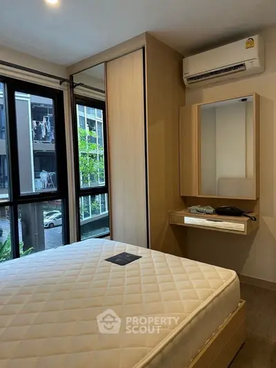 Modern bedroom with large window, built-in wardrobe, and air conditioning unit.