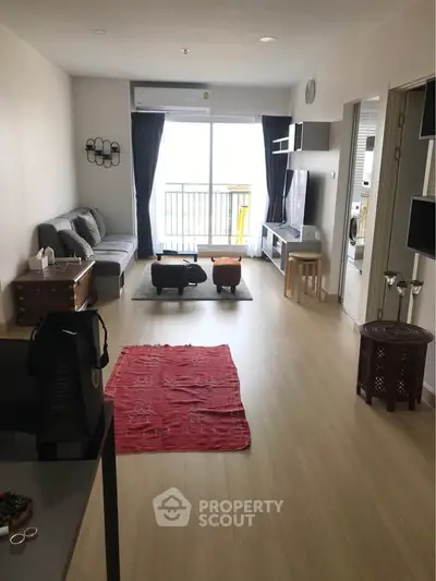 Spacious living room with modern decor and balcony access, perfect for relaxation and entertainment.