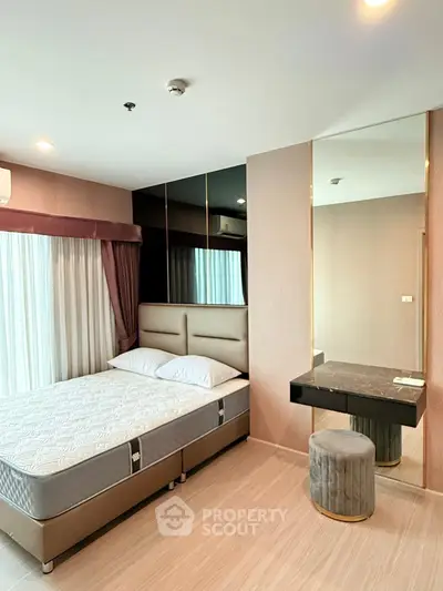 Modern bedroom with stylish decor and large mirror, featuring a comfortable bed and elegant furnishings.