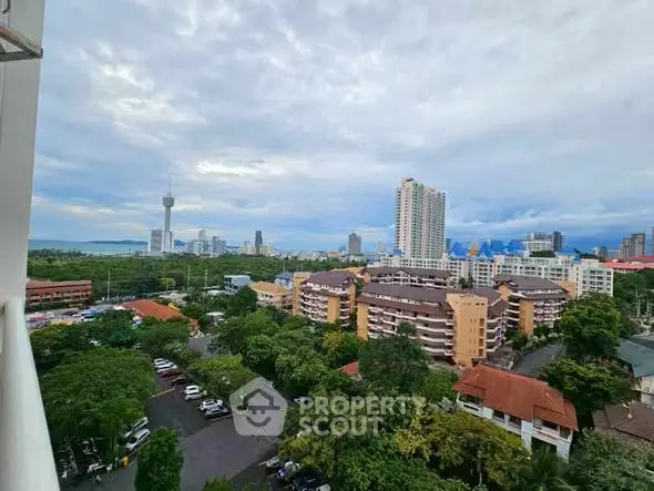 Stunning cityscape view from a high-rise balcony showcasing urban skyline and lush greenery.