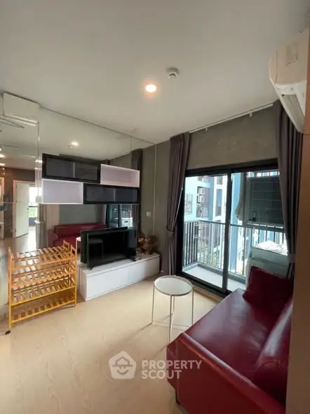 Modern living room with red sofa, large windows, and stylish decor in a contemporary apartment.