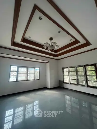 Spacious living room with elegant ceiling design and large windows for natural light.