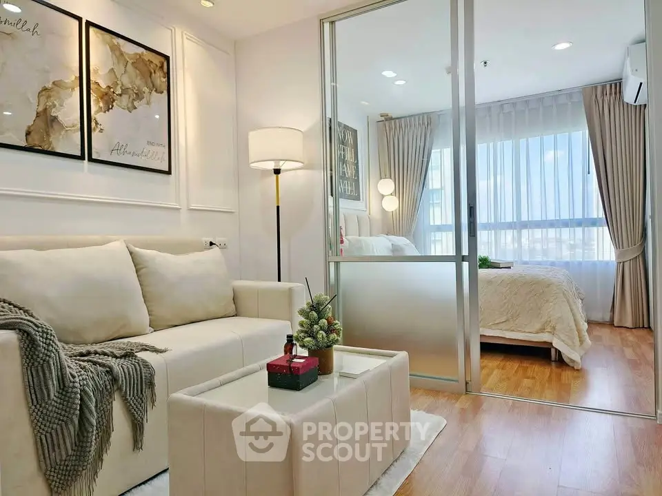 Modern apartment interior with cozy living room and elegant bedroom separated by glass partition.