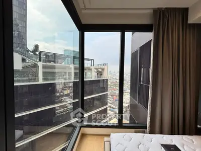 Stunning city view from modern high-rise apartment bedroom with large windows.