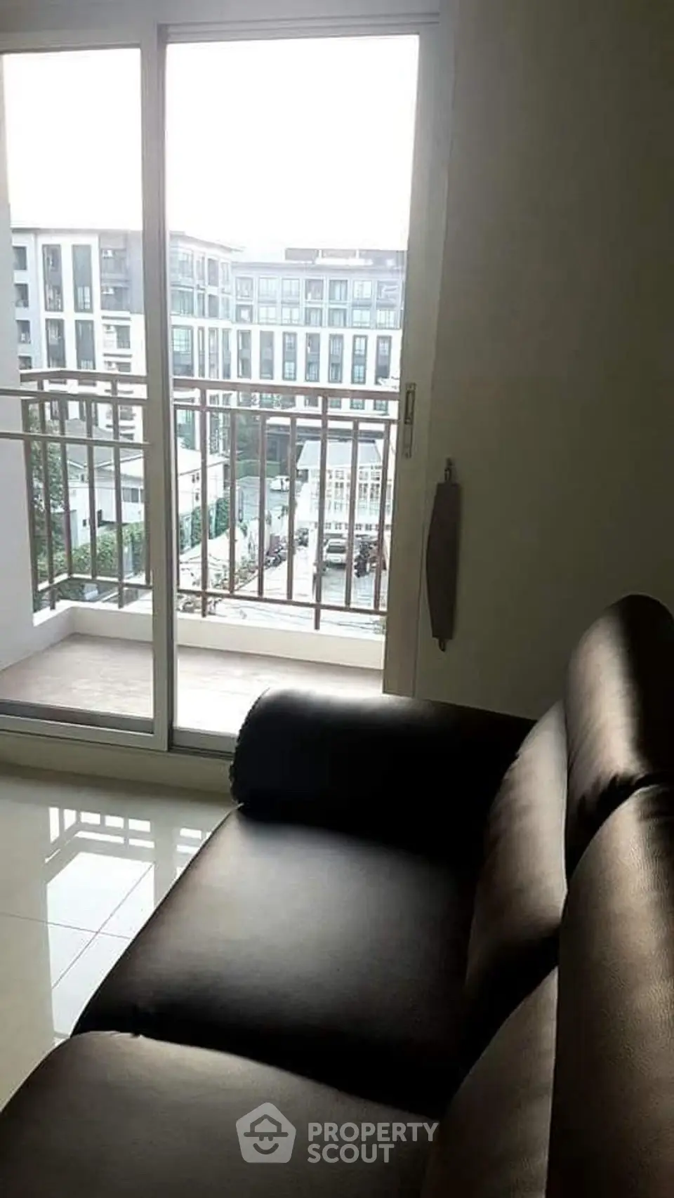 Modern apartment with balcony view and sleek leather sofa