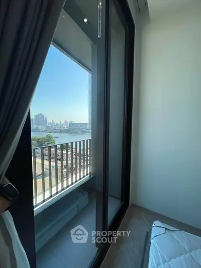Stunning bedroom with floor-to-ceiling windows offering breathtaking city and river views.