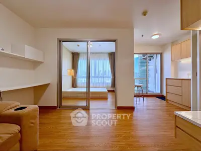 Spacious modern apartment with open layout and wooden flooring, featuring a cozy bedroom and ample natural light.