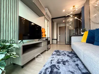 Modern living room with stylish decor and large TV, featuring cozy seating and elegant design.