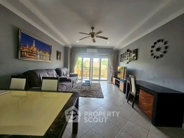Spacious living room with modern decor and large windows opening to a balcony.