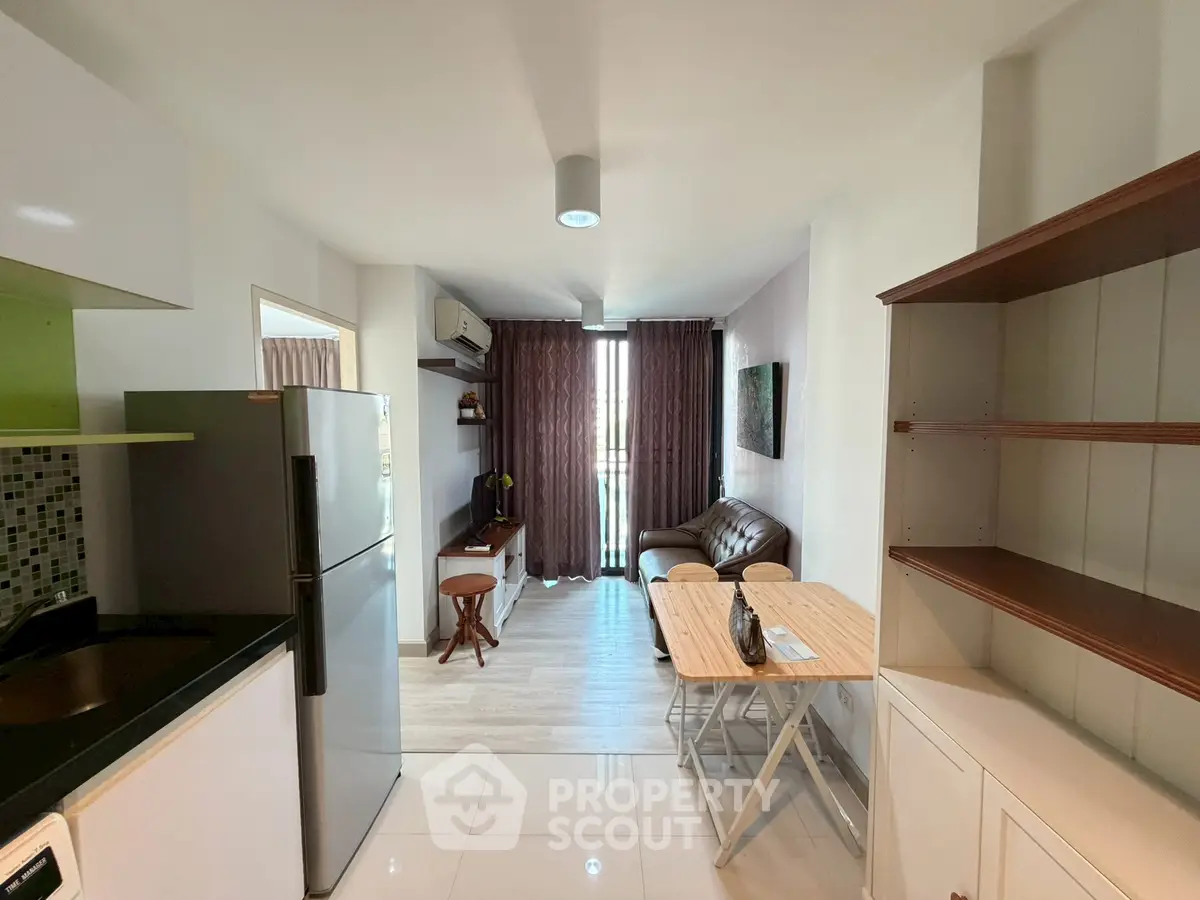 Modern apartment interior with open layout, featuring a cozy living area and sleek kitchen design.