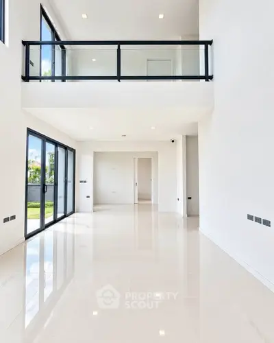 Spacious modern living room with high ceilings and large windows offering natural light.