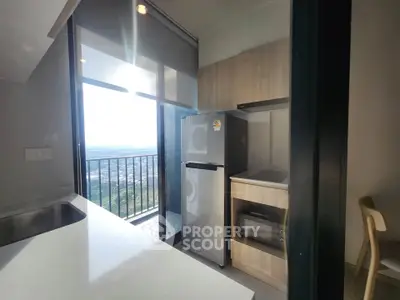 Modern kitchen with sleek appliances and balcony view in a high-rise apartment.